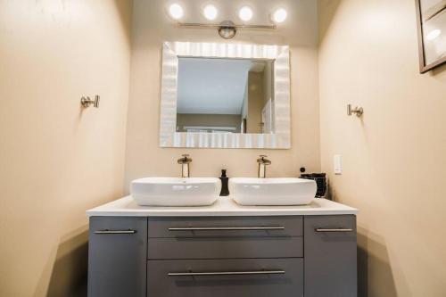 a bathroom with two sinks and a mirror at Modern Home of Style & Comfort! in Petoskey