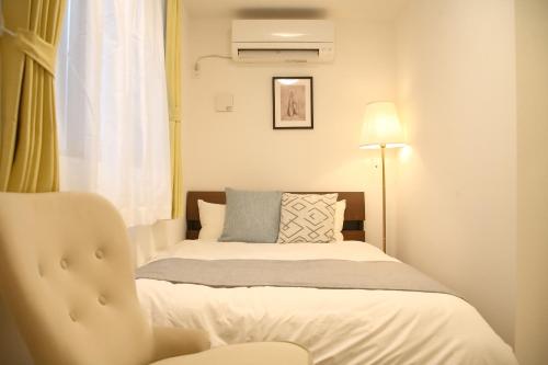 a small bedroom with a bed and a chair at Casa Stella 1 Aquarius by Liaison in Osaka