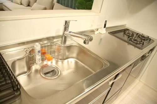 a stainless steel sink in a kitchen next to a stove at Casa Stella 1 Aquarius by Liaison in Osaka