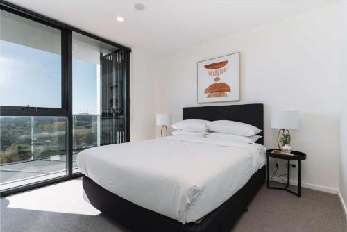 a bedroom with a large bed and a large window at Pristine 2-Bed Apartment with Pool and BBQ in Phillip