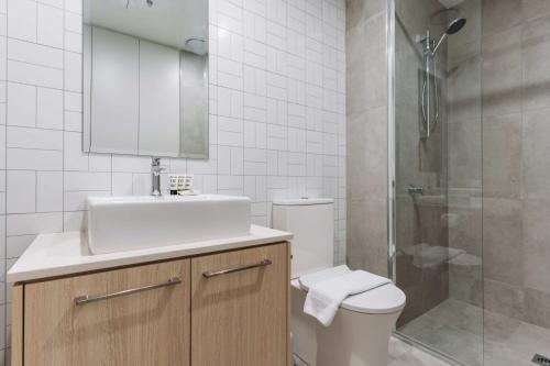 a bathroom with a toilet and a sink and a shower at Pristine 2-Bed Apartment with Pool and BBQ in Phillip