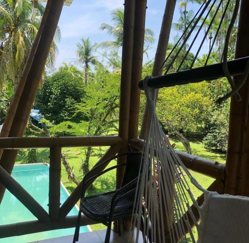 a hammock on a porch with a view of a pool at Carayurú in Mitú
