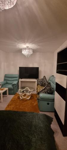 a living room with blue couches and a chandelier at large room for 2 sofa and TV in Newhaven