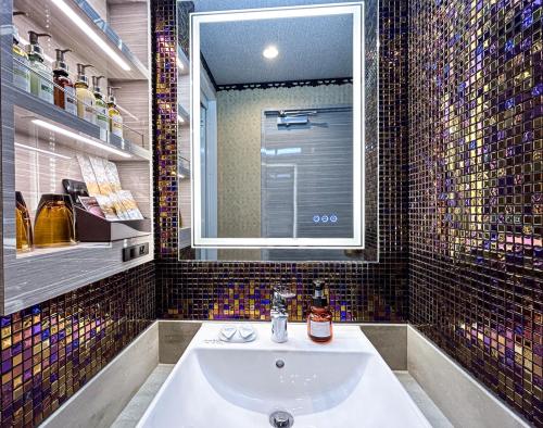 baño con lavabo y ventana grande en Hotel BaliBali 鶯谷, en Tokio