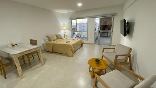 Una habitación de hotel con una cama, una mesa y sillas. en Orillas II, en Puerto Madryn