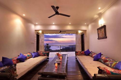 a living room with a couch and a ceiling fan at Villa Umbrella Lombok in Senggigi 