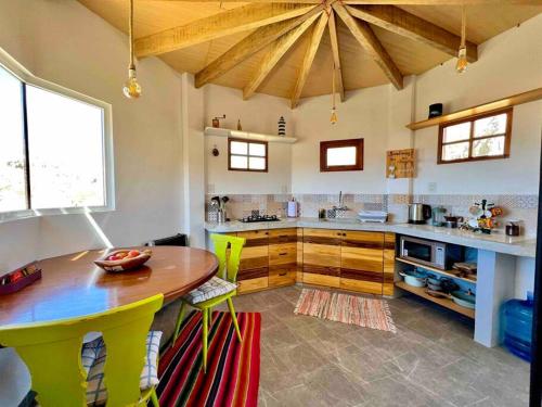 拉巴斯的住宿－Andean Lodge in La Paz，厨房配有木桌和黄色椅子