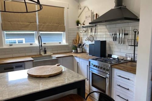 a kitchen with a wooden cutting board on a counter at Stones on Standish TAHI in Myrtleford