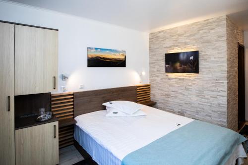 sypialnia z dużym łóżkiem i ceglaną ścianą w obiekcie Hotel Riviera w mieście Sinaia
