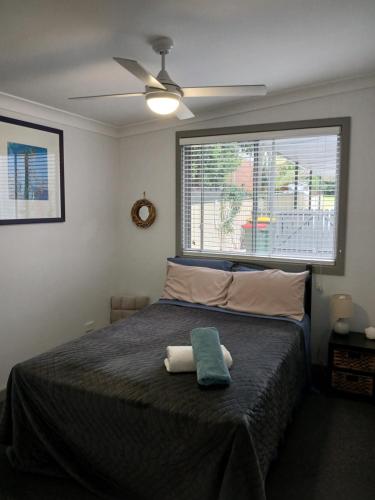 a bedroom with a bed with a green towel on it at Our Retreat in Forster