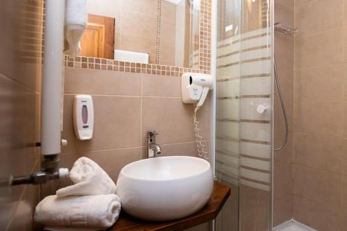 a bathroom with a sink and a shower at Hotel Riviera in Sinaia