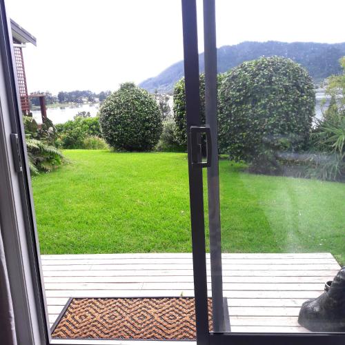an open door with a view of a yard at seaview in Tairua