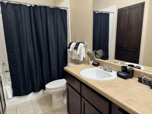 a bathroom with a sink and a black shower curtain at Magnolia Serenity: 2BD/1BA w/ Gym, Pool, BBQ Grill in Tupelo