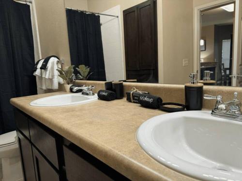 a bathroom with two sinks and a large mirror at Magnolia Serenity: 2BD/1BA w/ Gym, Pool, BBQ Grill in Tupelo