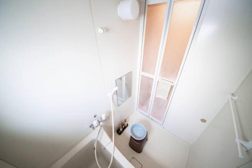a white bathroom with a toilet and a window at Learch Asahikawa in Asahikawa