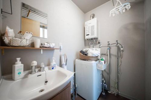 a small kitchen with a sink and a refrigerator at Learch Asahikawa in Asahikawa