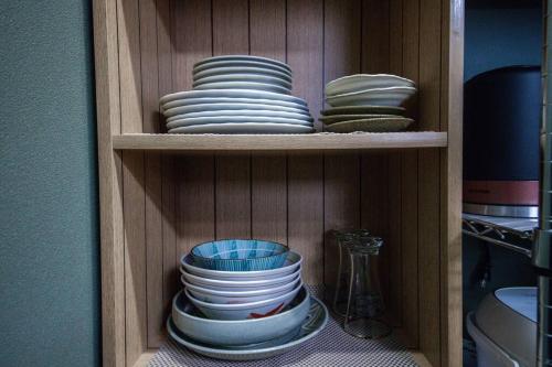 a cabinet filled with plates and bowls at Learch Asahikawa in Asahikawa