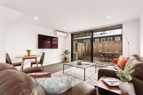 a living room with a couch and a table at Funky Spacious 2Bdrms 2Bthrms Free Covered Park. in Christchurch