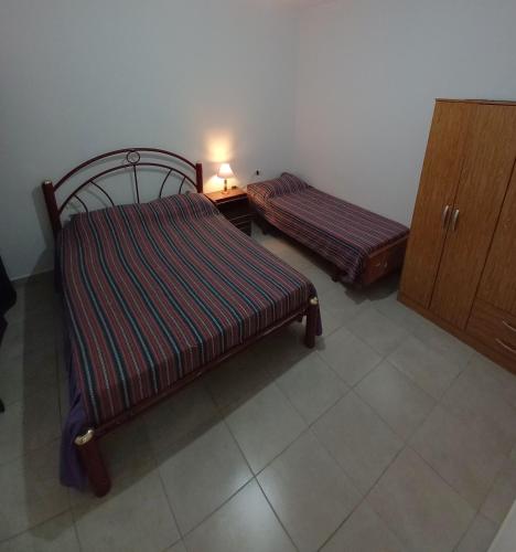 ein Schlafzimmer mit 2 Betten und einem Tisch mit einer Lampe in der Unterkunft Departamento La Lita in Chilecito