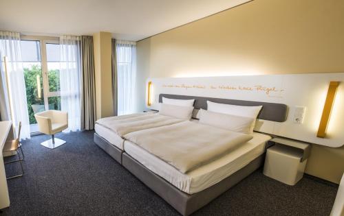 ein Schlafzimmer mit einem großen Bett in einem Zimmer in der Unterkunft Lufthansa Seeheim - More than a Conference Hotel in Seeheim-Jugenheim