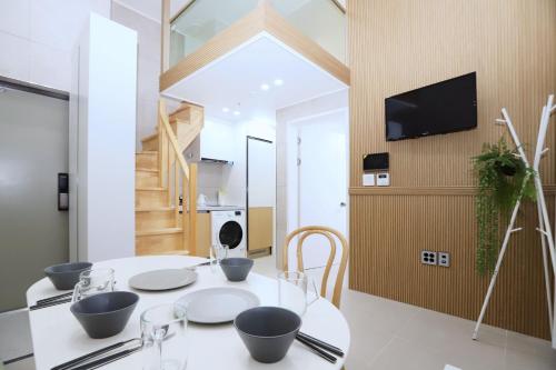 a dining room with a table and a tv at The Loft Homely in Seoul