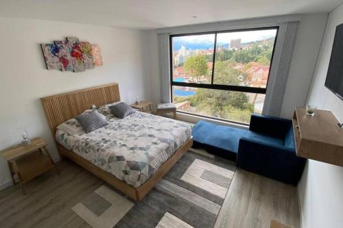 um quarto com uma cama e uma grande janela em Loft en Centro Internacional con Vista Increíble em Bogotá