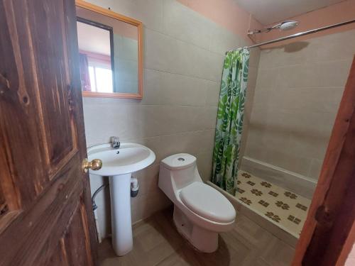 Un baño con inodoro, lavabo y ducha. en casamares - casanon, en San José Pinula