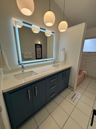 a bathroom with a sink and a mirror at Hojo House Winnipeg in Winnipeg