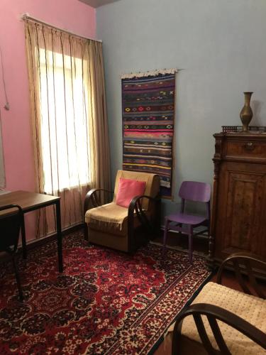 a living room with a chair and a table and a window at Дом Кети в туристическом районе Тбилиси-авлабари in Tbilisi City