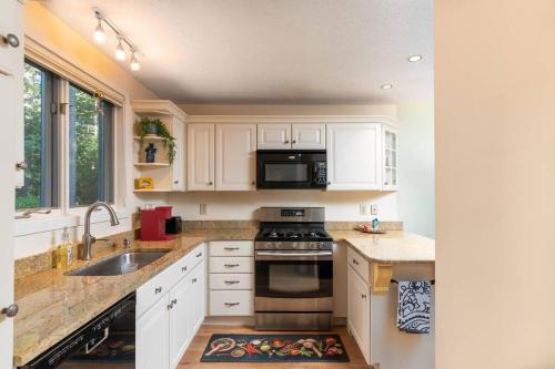 a kitchen with white cabinets and a stove top oven at Family-friendly townhouse in a great location! in North Conway
