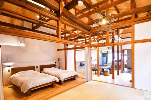 Duas camas num quarto com tectos em madeira em GuestHouseYULLAT em Horiechō