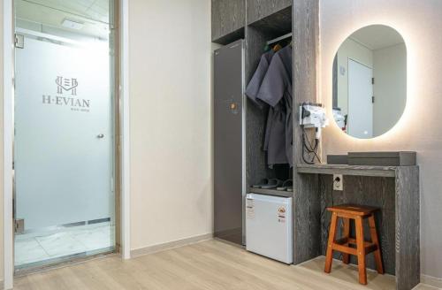 a bathroom with a vanity and a mirror and a stool at H-Evian Hotel in Gwangju