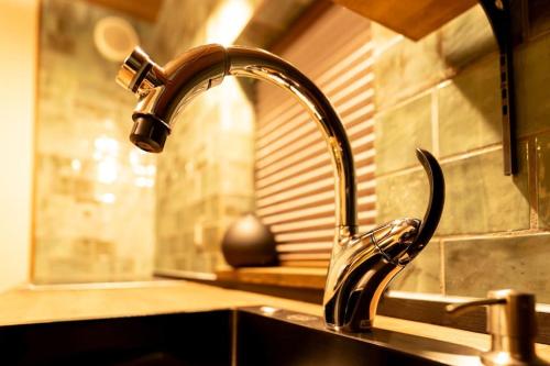 a kitchen sink with a faucet on a counter at 旅宿うさぎとかめ Guest House USAGI to KAME 近江八幡中心地 ヴォーリズ建築好きにお勧め in Hachiman
