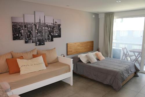 1 dormitorio con 1 cama y 1 sofá en Chula Vista - Depto con vista al mar en Punta Mogotes en Mar del Plata