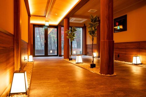 a hallway with lights and plants in a building at Motosu Phoenix Hotel in Fujikawaguchiko