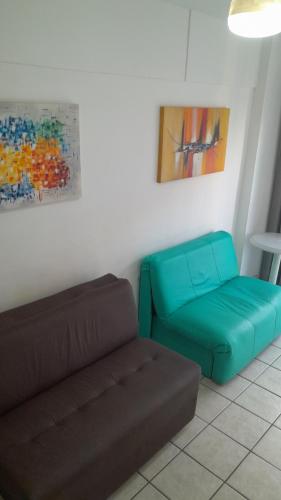 a living room with a couch and a chair at Condomínio com Piscina, 1vaga Garagem, WI-FI 300 Mbps, Home Office, Portaria 24hs, churrasqueira, playground, Centro de Guarujá, próximo da Praia e do Comércio in Guarujá