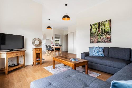 a living room with a couch and a tv at Sunrise Cottage- Dover Tasmania in Dover