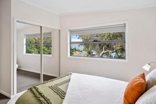 a bedroom with two windows and a bed at Ocean View Cottages in Dover, Far South Tasmania in Dover