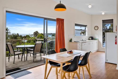 a kitchen and dining room with a table and chairs at Sunrise Cottage- Dover Tasmania in Dover