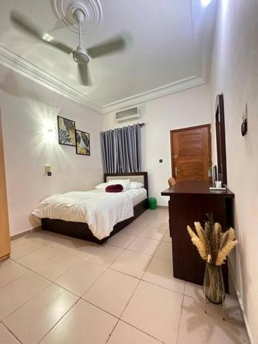 a bedroom with a bed and a table in a room at Quick Apartments in Cotonou
