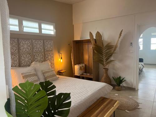 a bedroom with a bed and plants in it at Appartement 2 chambres Sainte-Luce in Sainte-Luce