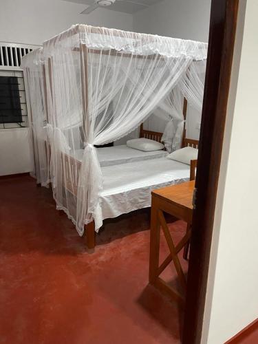 a bedroom with a bed with a mosquito net at Pacifia Villa in Bentota
