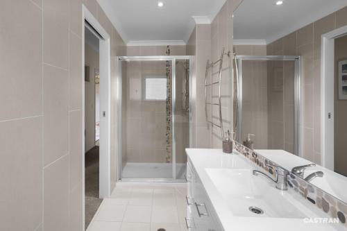 a white bathroom with a sink and a shower at Mayfair in Dinner Plain