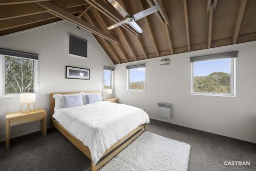 a bedroom with a bed and two windows at Mayfair in Dinner Plain
