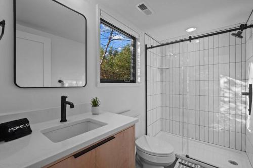 a bathroom with a sink and a toilet and a mirror at Tiny Home, Near Downtown Durham, Duke & 9th Street! in Durham