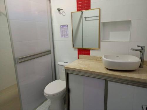 a bathroom with a sink and a toilet and a mirror at Cabañas Privadas en Playas del Francés con Piscina in San Silvestre