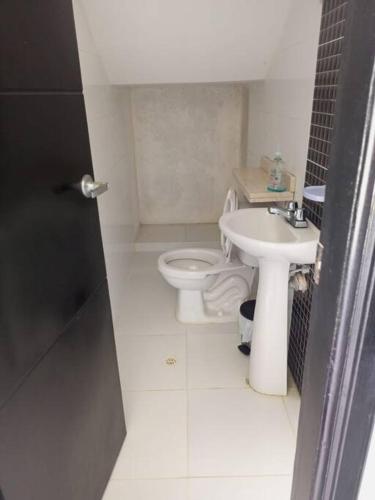 a small bathroom with a toilet and a sink at Cabañas Privadas en Playas del Francés con Piscina in San Silvestre