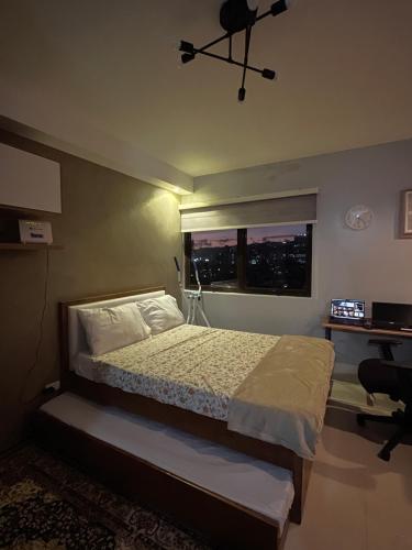 um quarto com uma cama, uma janela e uma secretária em JP Persimmon Cebu Staycation em Cebu