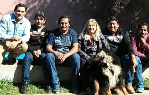 a group of people sitting on a bench with a dog at Casa Pato in Mariano J. Haedo