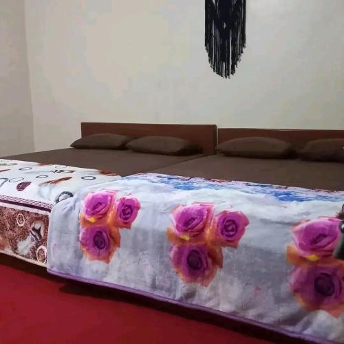 Una cama con rosas rosas. en MAJA HOUSE 2, en Tambakrejo